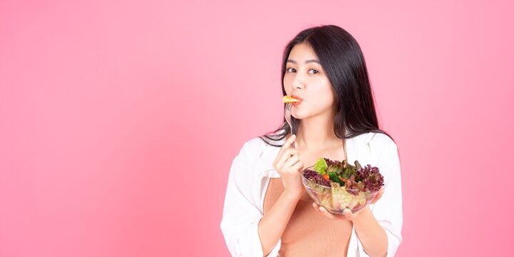 woman with clear skin eating fruits