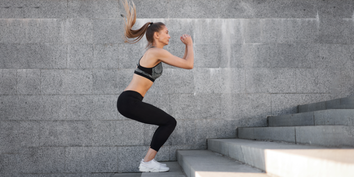 Woman performing Jump squat on stairs