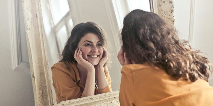 Woman looking at mirror happily
